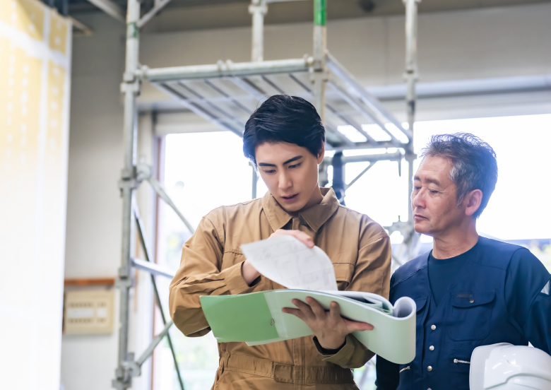 資料を見ながら話しをしている男性二人